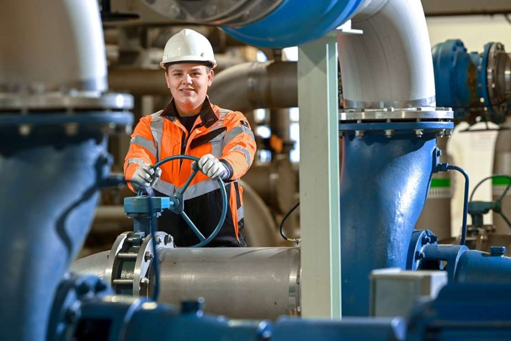 Mann bedient Steuerungsrad im Wasserwerk