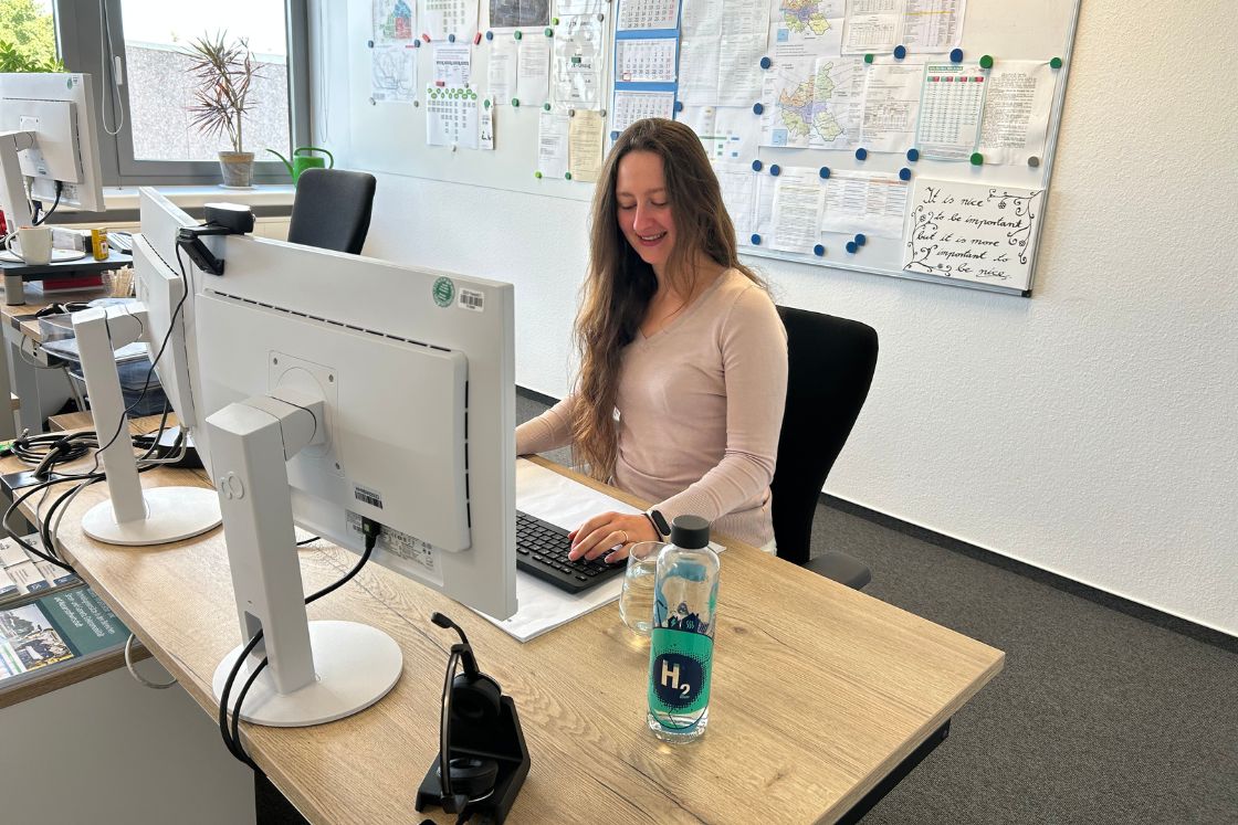 Junge Frau an ihrem Arbeitsplatz im Büro