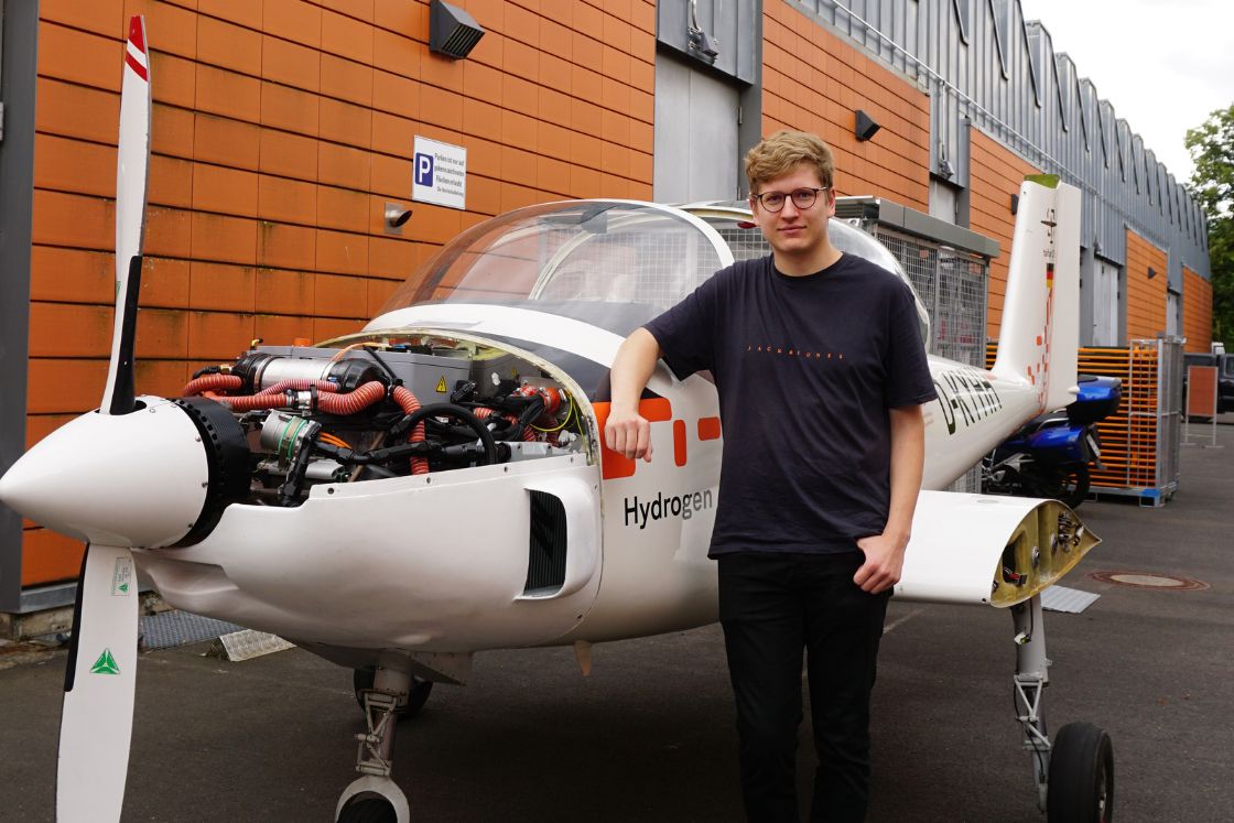 junger mann steht vor leichtflugzeug