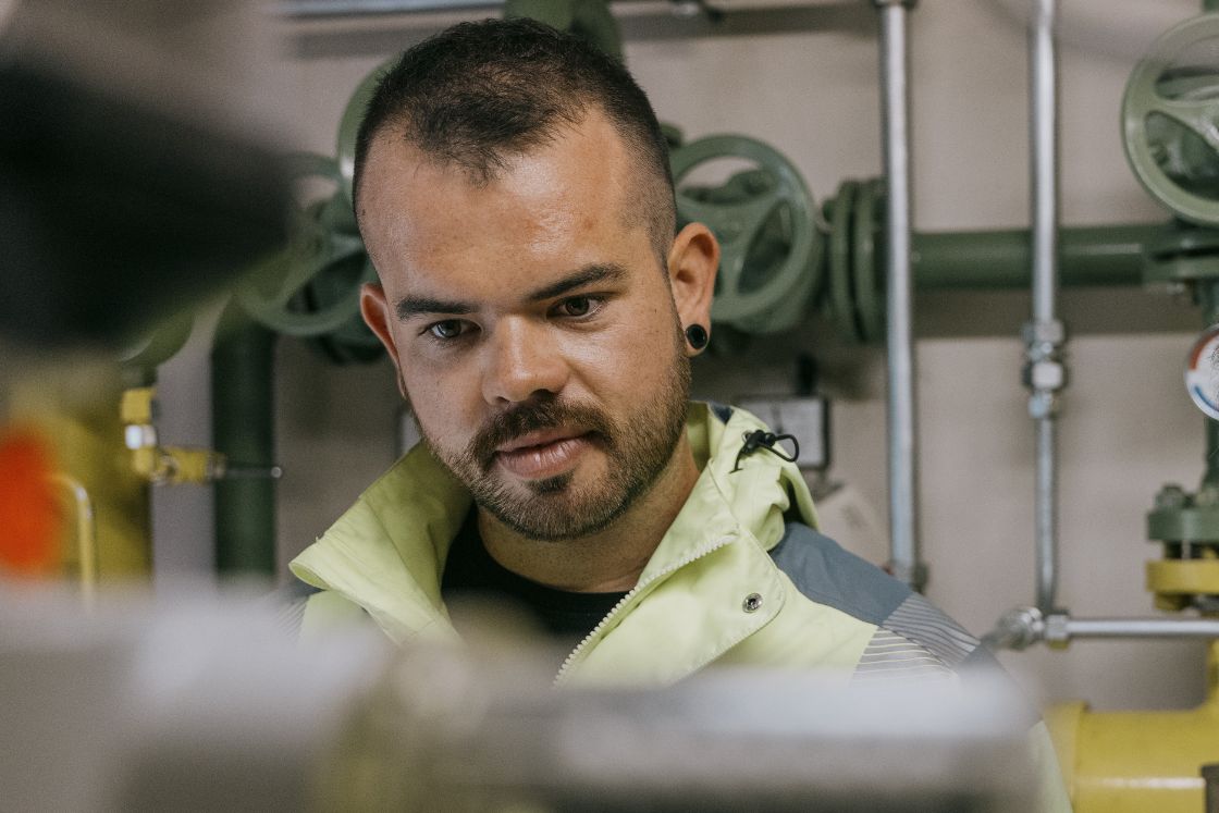 Junger Mann blickt konzentriert auf die Anlagen im Bereich Energie und Wasser.