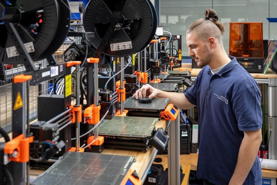 Junger Mann begutachtet einen 3D-Druck.