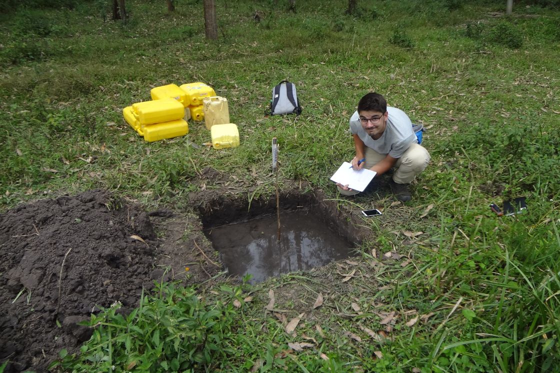 Junger Mann mit Schreibblock vor einem ausgehobenen Wasserbecken