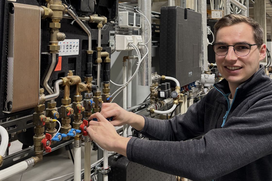 junger Mann an Heizungsanlage